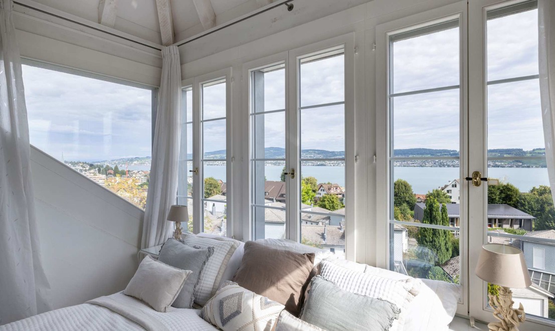 Hauptschlafzimmer mit Fensterfront zum See